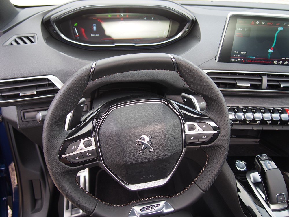 The driver sees over the top of the small steering wheel into the digital instrumentation.